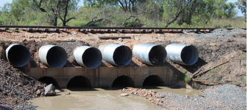 lNADEQUATE: Emerald business owner Roy Woods says the current LN1 drain, despite the addition of six new pipes, doesn’t allow for fast flowing floodwaters. INSET: Roy Woods stands by a pile of tyres that indicate the floodwater level reached in the yard at Woods’ Tyres. tm-250111-006 lNADEQUATE: Emerald business owner Roy Woods says the current LN1 drain, despite the addition of six new pipes, doesn’t allow for fast flowing floodwaters. INSET: Roy Woods stands by a pile of tyres that indicate the floodwater level reached in the yard at Woods’ Tyres. tm-250111-006